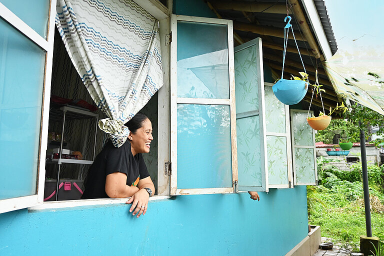 Photo: Hilti: Woman looking out a blue house