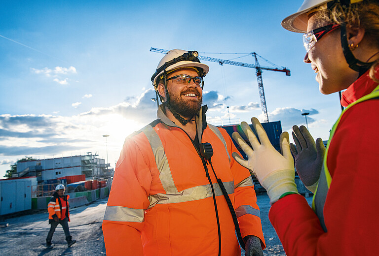 Photo: Hilti: Two workers talking in a construction site at sunrise