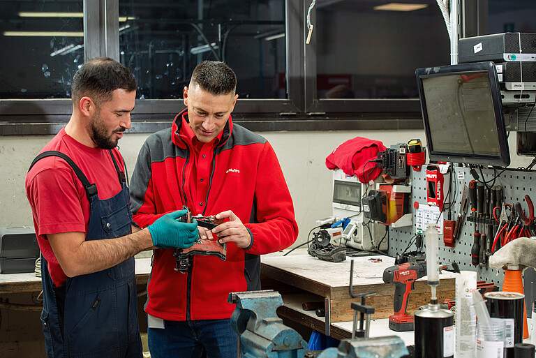 Photo: Hilti: Two people repairing Hilti equipment 