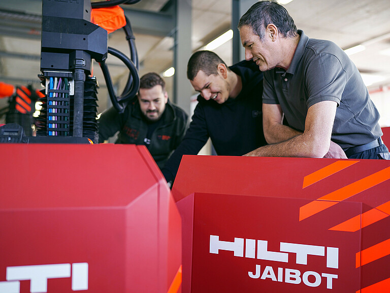 Photo: Hilti: Three people standing behind a Jaibot