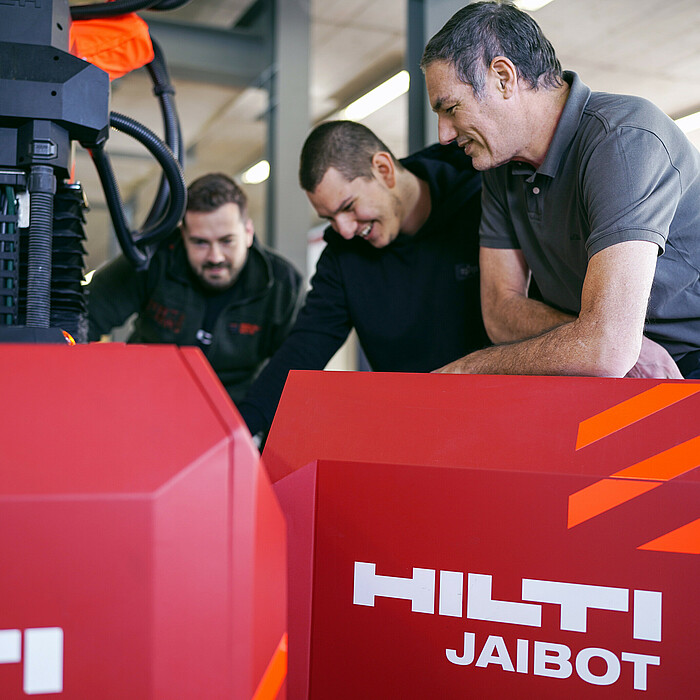Photo: Hilti: Three people standing behind a Jaibot