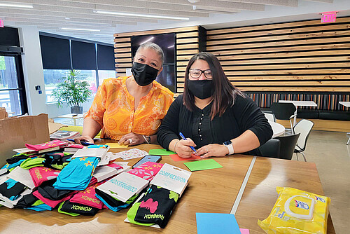 Photo: Hilti: Two people writing post cards on a table