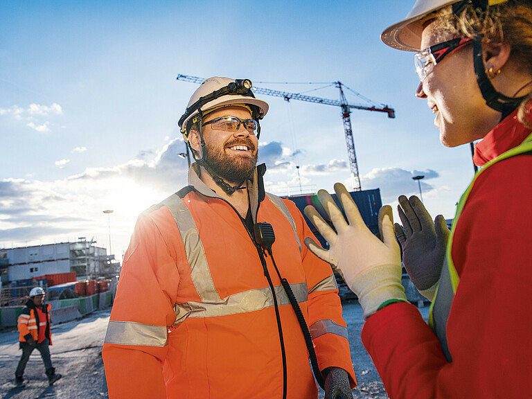 Photo: Hilti: Two workers talking in a construction site at sunrise