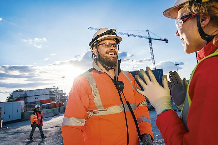 Photo: Hilti: Two workers talking in a construction site at sunrise