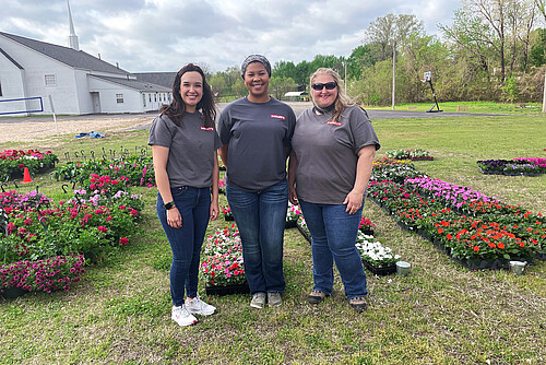 Photo: Hilti: Three people standing in a garden next to a church