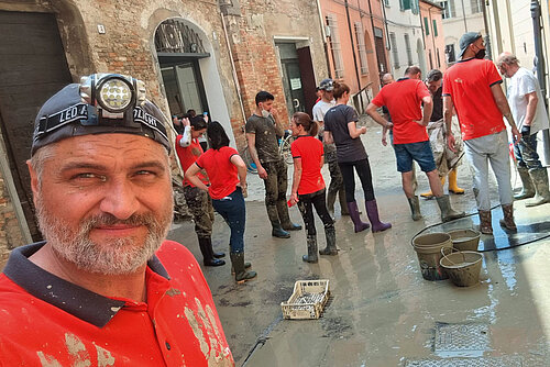 Photo: Hilti: A man with a head torch takes a selfie with workers in the background.