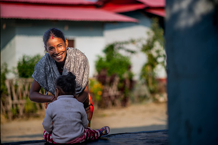 Photo: Hilti: A woman with a child sitting outside, the woman is looking in the camera smiling