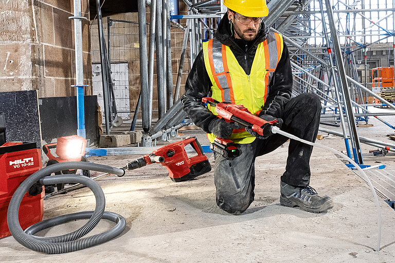 Photo: Hilti: A man with a yellow helmet on a construction site working with Hilti tools