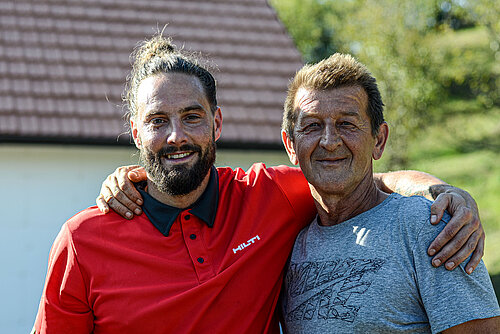 Photo: Hilti: Two men standing arm in arm smile into the camera.