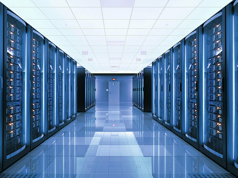 Photo: Hilti: A server room with many servers left and right and blue light