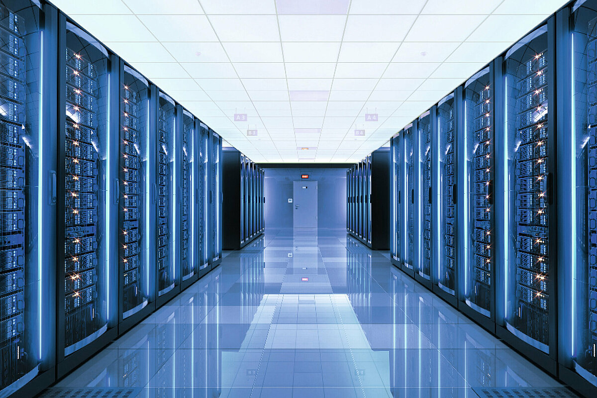 Photo: Hilti: A server room with many servers left and right and blue light