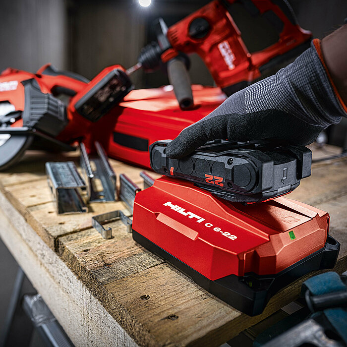 Photo: Hilti: Closeup of a Hilti tool on a table, somebody is attached a Nuron battery