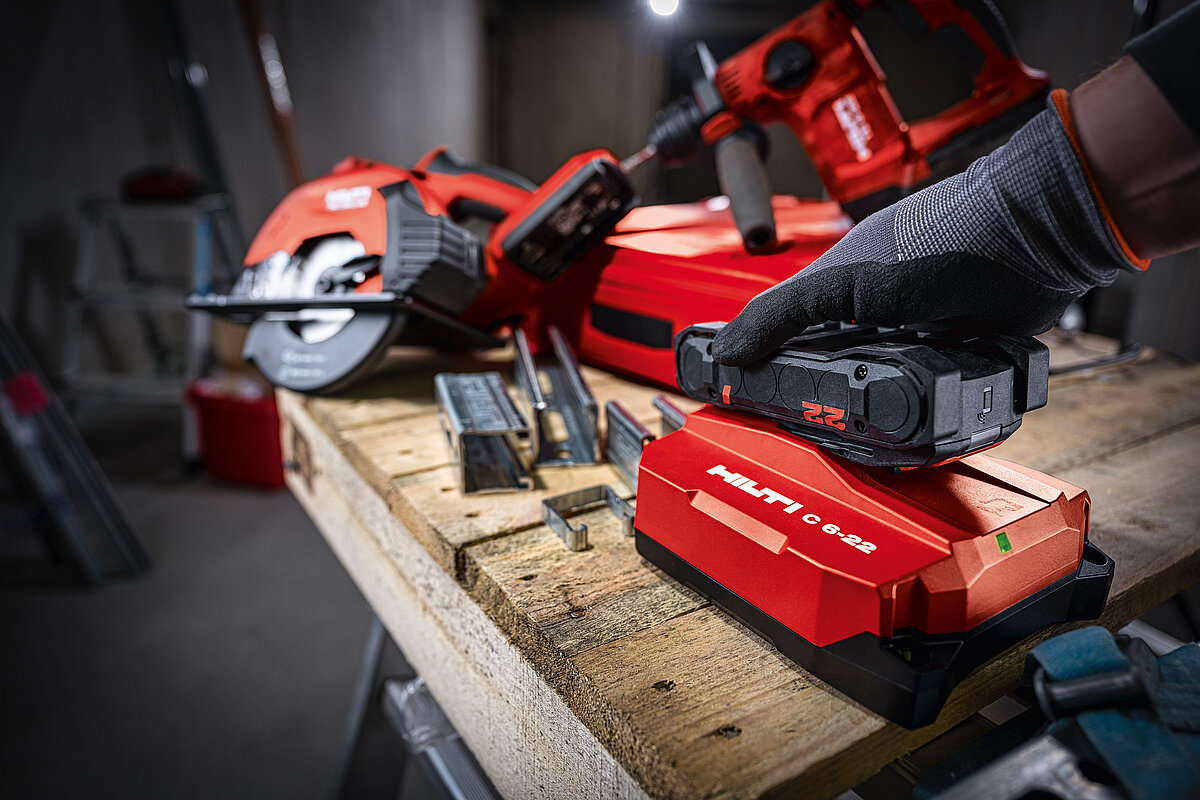 Photo: Hilti: Closeup of a Hilti tool on a table, somebody is attached a Nuron battery
