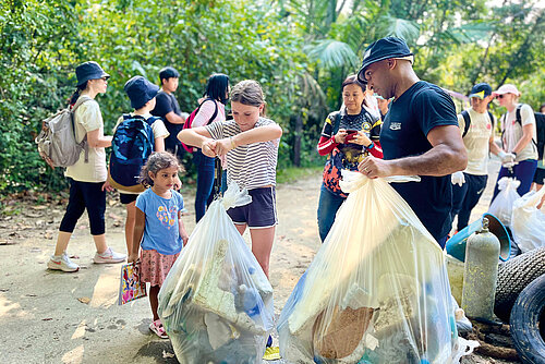 Photo: Hilti: Children helping collecting trash from nature in huge plastic bags.