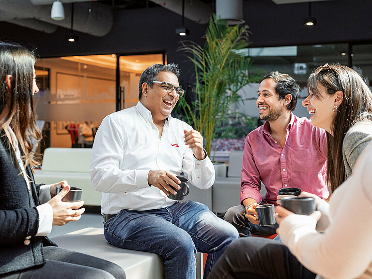 Photo: Hilti: Some people sitting in a lobby with cups in their hands talking