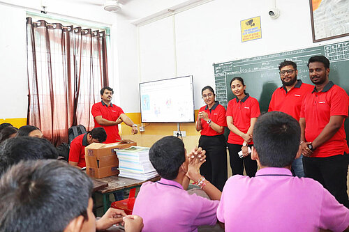 Photo: Hilti: A group of Hilti India volunteers stands at the front of a classroom, while school students sit at their desks, attentively facing them