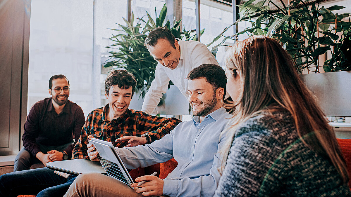 Photo: Hilti: a team of workers looking at a laptop screen and smiling