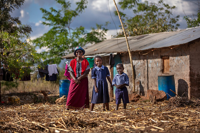 Photo: Hilti: A woman with two children stands in front of a house. Laundry and a chicken are visible in the background