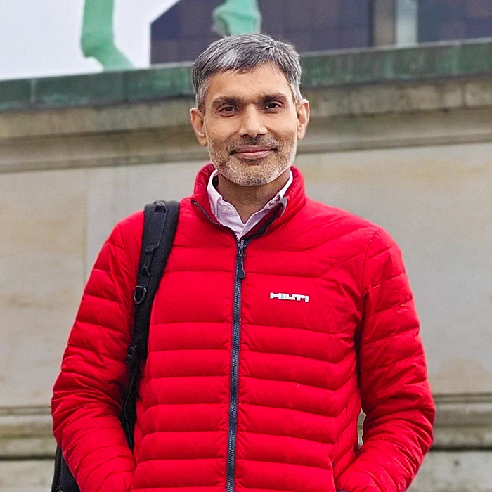 Akash Chauhan, construction project director in the Netherlands, wearing a backpack and a red Hilti work jacket.