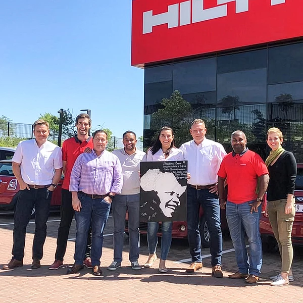 Group photo of Banu Deniz Çetinkol, general manager of Hilti Türkiye, and colleagues in front of a Hilti building.